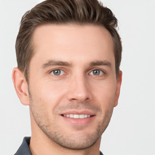 Joyful white young-adult male with short  brown hair and grey eyes