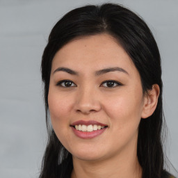 Joyful asian young-adult female with long  brown hair and brown eyes