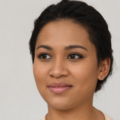Joyful latino young-adult female with short  black hair and brown eyes