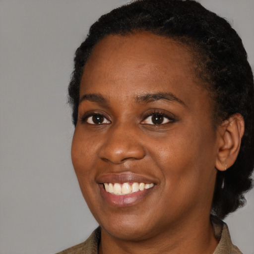 Joyful black young-adult female with short  brown hair and brown eyes