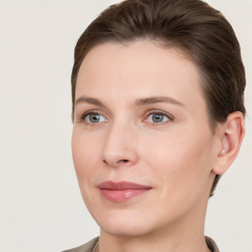 Joyful white young-adult female with short  brown hair and grey eyes