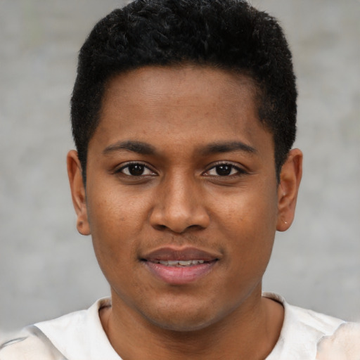Joyful black young-adult male with short  brown hair and brown eyes