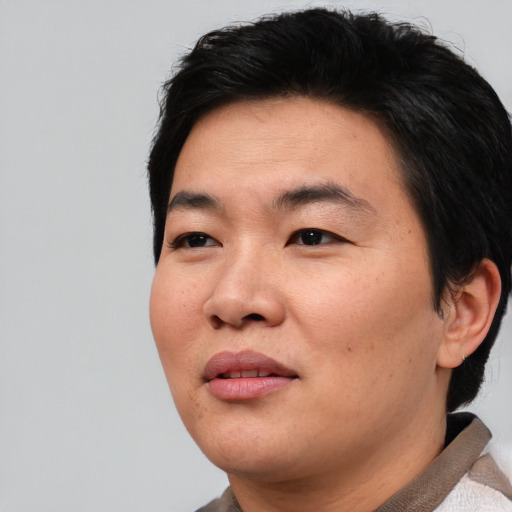 Joyful asian young-adult male with short  black hair and brown eyes