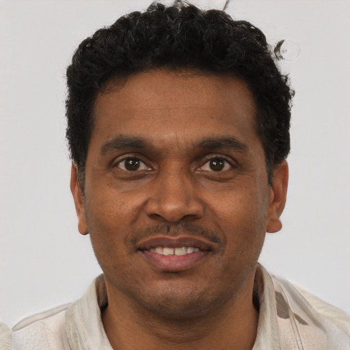 Joyful black young-adult male with short  brown hair and brown eyes