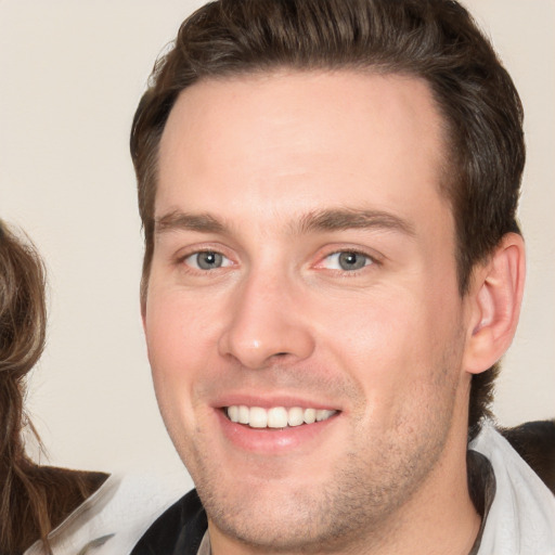 Joyful white young-adult male with short  brown hair and brown eyes