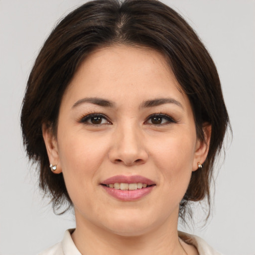 Joyful asian young-adult female with medium  brown hair and brown eyes