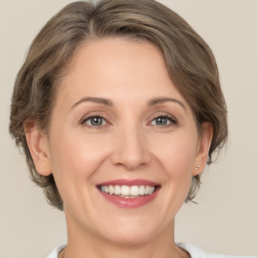 Joyful white adult female with medium  brown hair and grey eyes