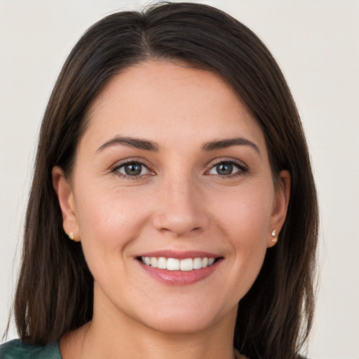 Joyful white young-adult female with long  brown hair and brown eyes