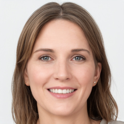 Joyful white young-adult female with medium  brown hair and grey eyes