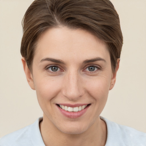 Joyful white young-adult female with short  brown hair and grey eyes