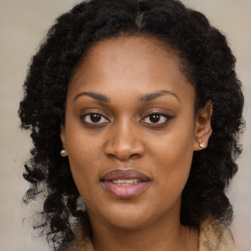 Joyful black young-adult female with long  brown hair and brown eyes