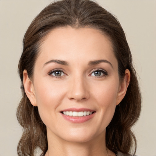 Joyful white young-adult female with medium  brown hair and grey eyes