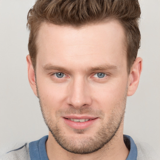 Joyful white young-adult male with short  brown hair and grey eyes