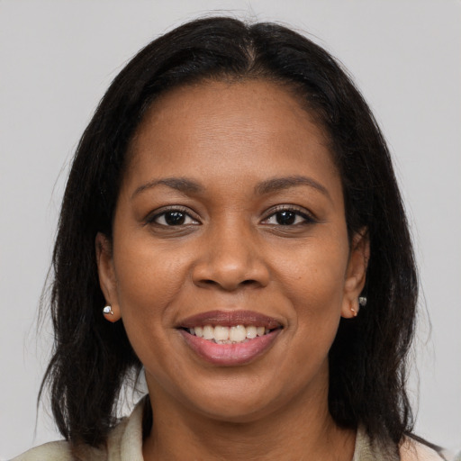Joyful black adult female with medium  brown hair and brown eyes