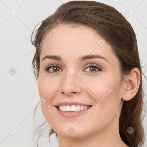 Joyful white young-adult female with long  brown hair and green eyes