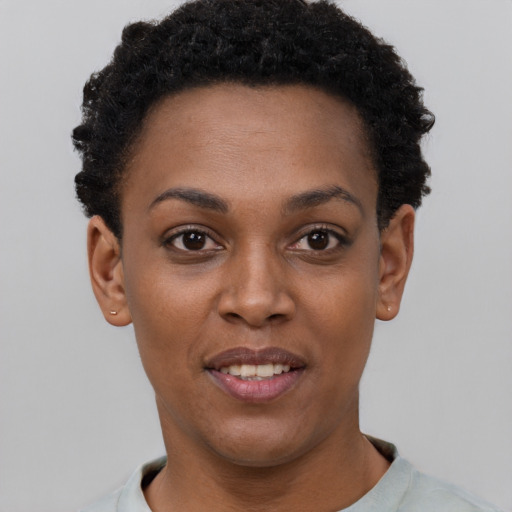 Joyful black young-adult female with short  black hair and brown eyes