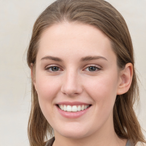 Joyful white young-adult female with long  brown hair and grey eyes