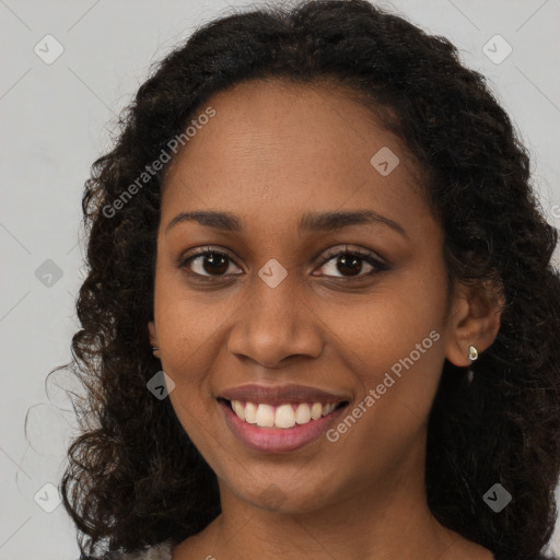 Joyful black young-adult female with long  brown hair and brown eyes