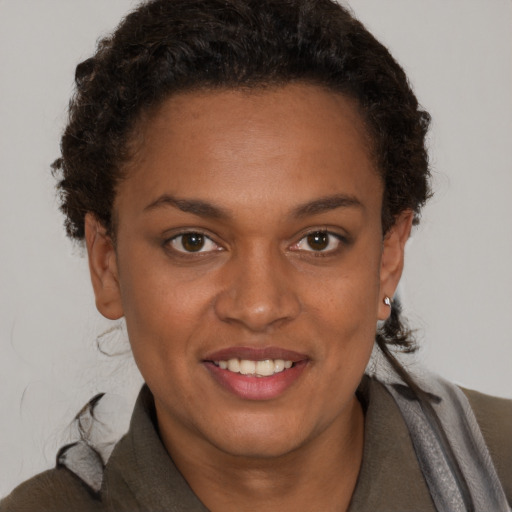 Joyful black young-adult female with short  brown hair and brown eyes