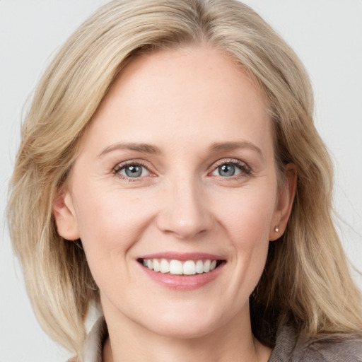 Joyful white young-adult female with medium  brown hair and blue eyes