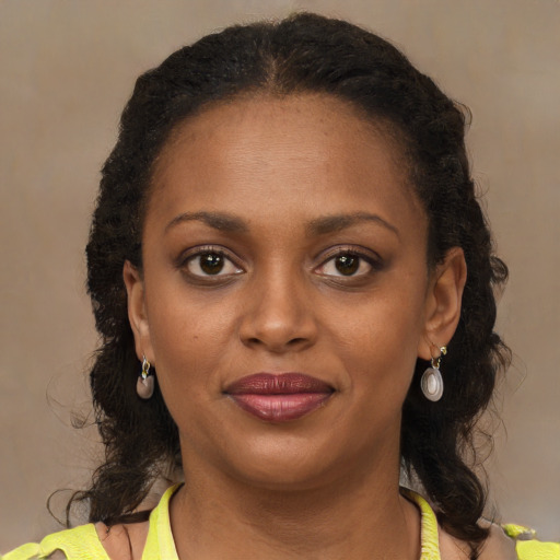 Joyful black young-adult female with long  brown hair and brown eyes