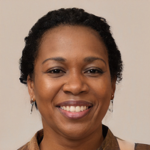Joyful black adult female with medium  brown hair and brown eyes