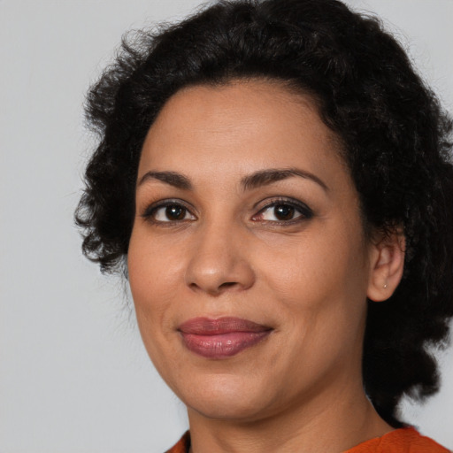 Joyful latino adult female with medium  black hair and brown eyes