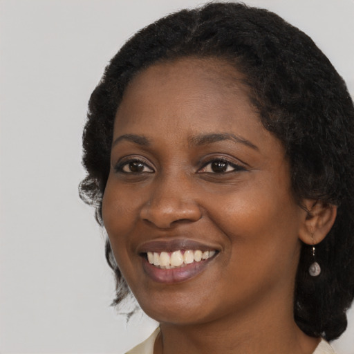 Joyful black young-adult female with long  black hair and brown eyes