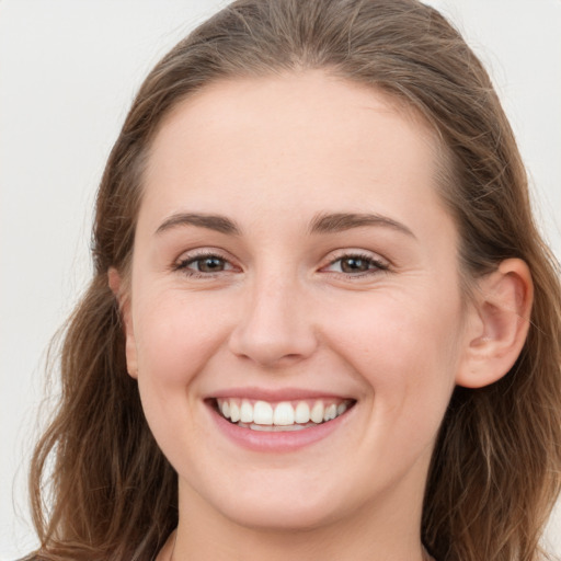 Joyful white young-adult female with long  brown hair and grey eyes