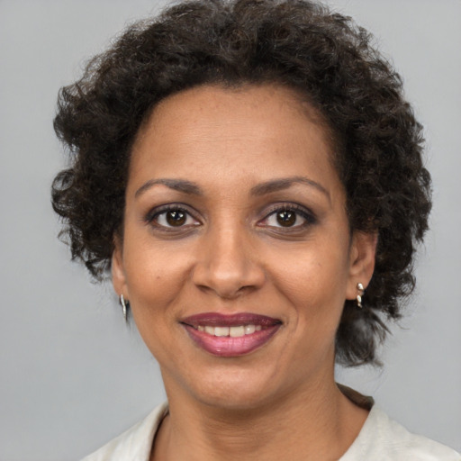 Joyful black adult female with short  brown hair and brown eyes