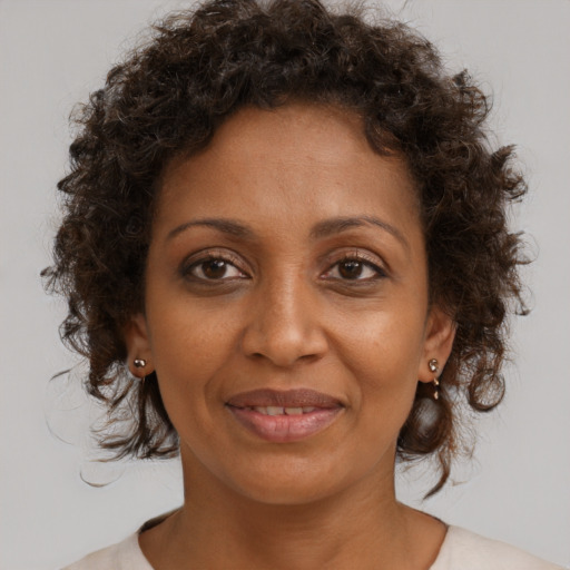 Joyful black adult female with medium  brown hair and brown eyes