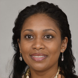 Joyful black adult female with long  brown hair and brown eyes