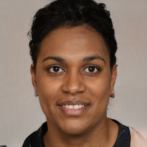 Joyful black young-adult female with short  black hair and brown eyes