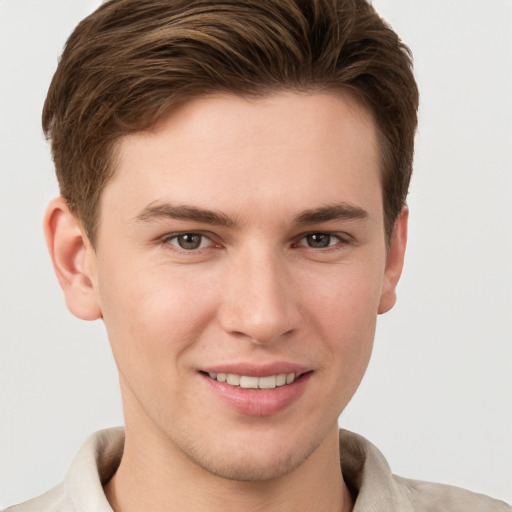 Joyful white young-adult male with short  brown hair and grey eyes