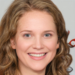 Joyful white young-adult female with long  brown hair and blue eyes