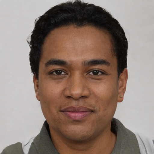 Joyful latino young-adult male with short  black hair and brown eyes