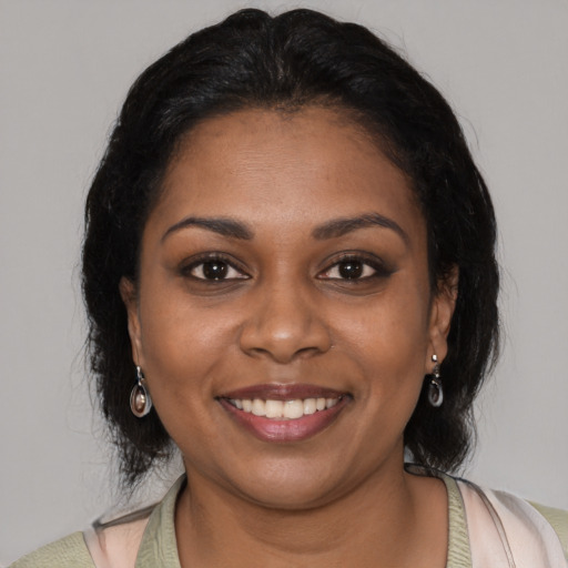 Joyful black young-adult female with medium  black hair and brown eyes