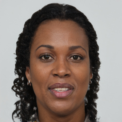 Joyful black adult female with long  brown hair and brown eyes