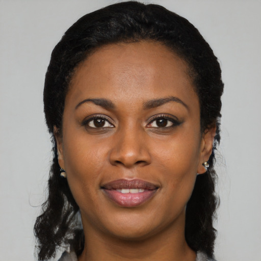 Joyful black young-adult female with long  black hair and brown eyes