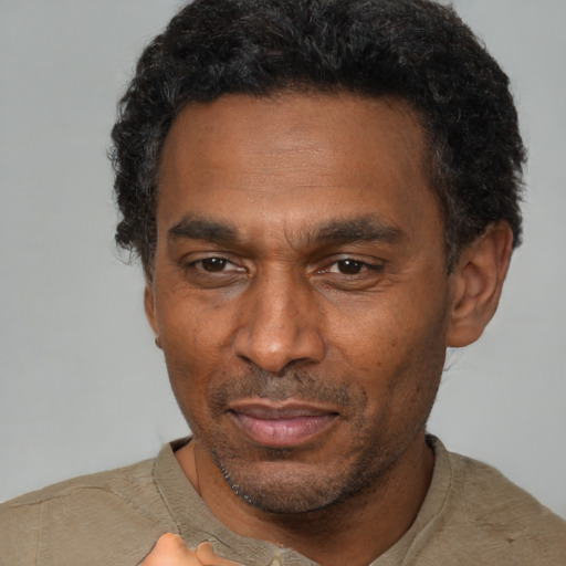 Joyful latino adult male with short  black hair and brown eyes