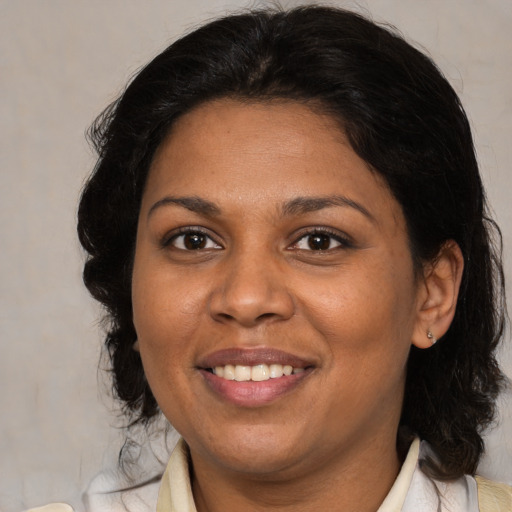 Joyful black adult female with medium  brown hair and brown eyes