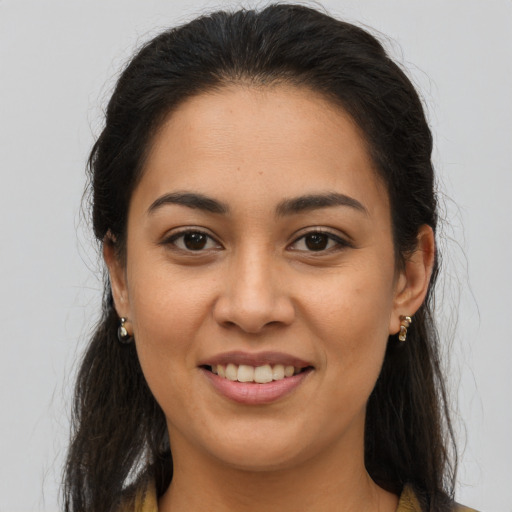Joyful latino young-adult female with long  brown hair and brown eyes