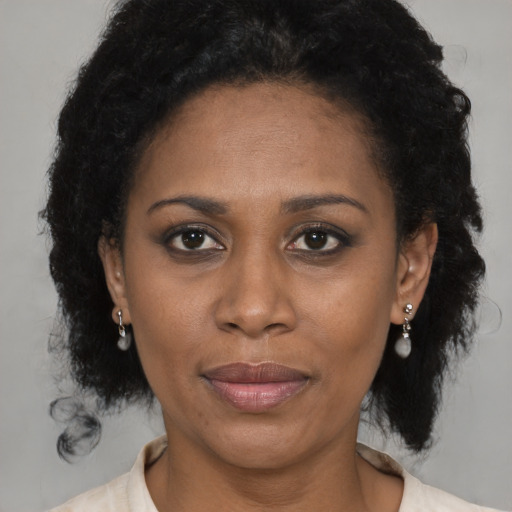Joyful latino adult female with medium  brown hair and brown eyes