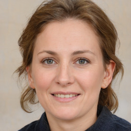 Joyful white adult female with medium  brown hair and blue eyes