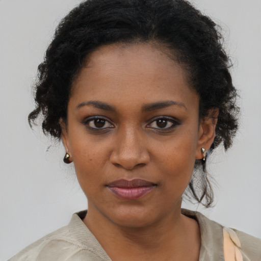 Joyful black young-adult female with medium  brown hair and brown eyes
