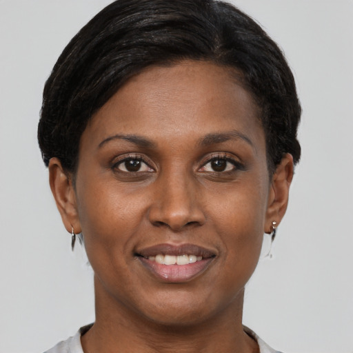 Joyful black young-adult female with short  brown hair and brown eyes