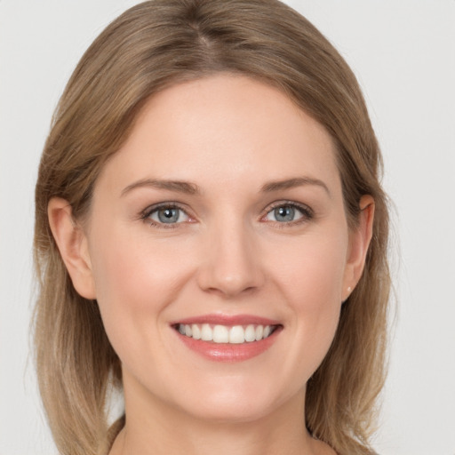 Joyful white young-adult female with medium  brown hair and grey eyes