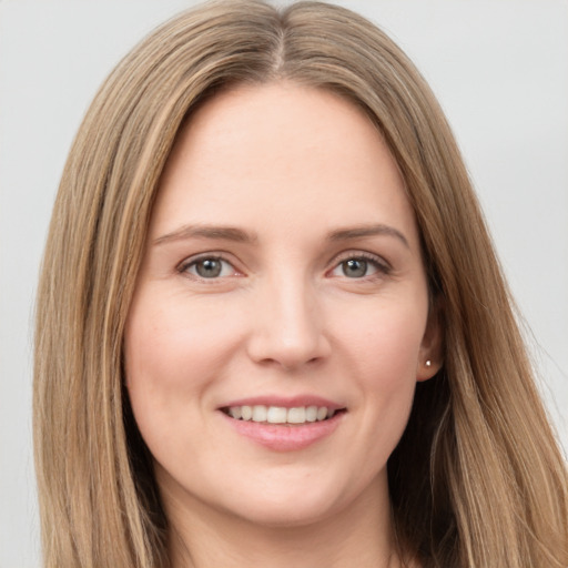 Joyful white young-adult female with long  brown hair and grey eyes