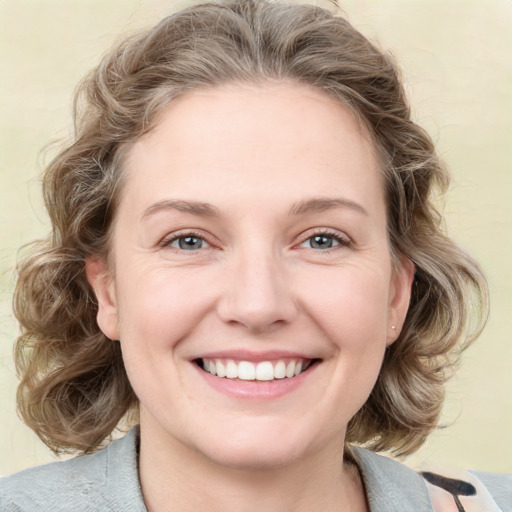 Joyful white young-adult female with medium  brown hair and blue eyes