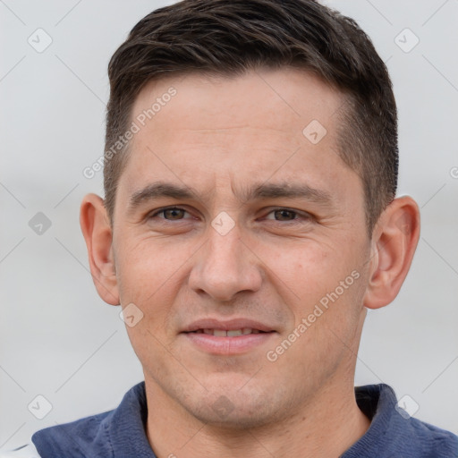 Joyful white young-adult male with short  brown hair and grey eyes